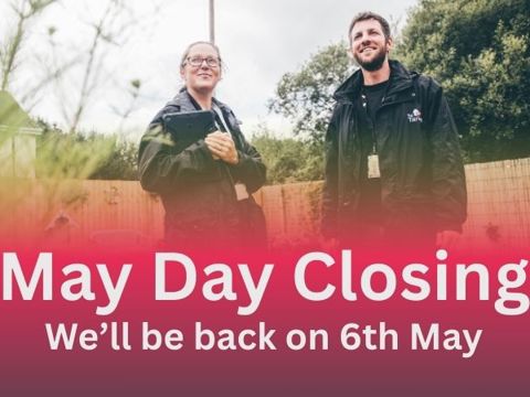 Two Tai Tarian staff members with a banner below with the headline of May Day closing