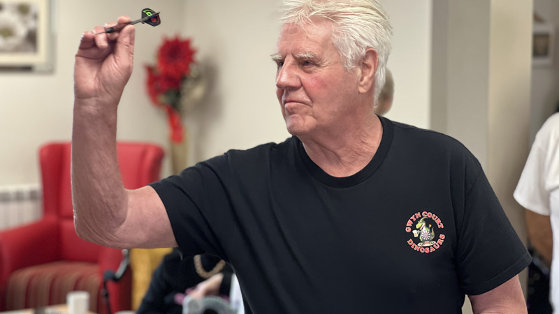 Haven resident aiming a dart at the dartboard