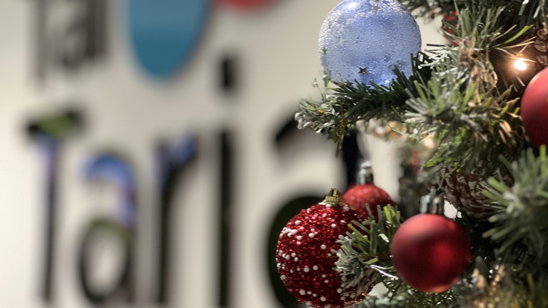 Christmas tree in front of a Tai Tarian sign