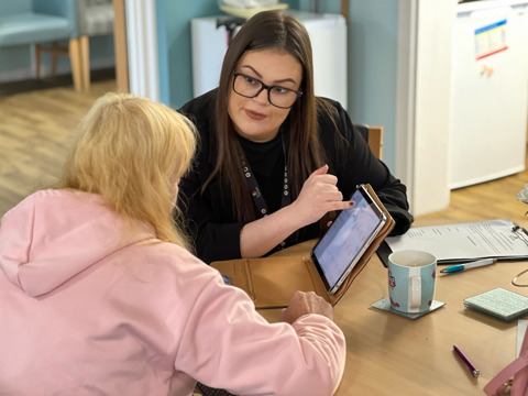 Hannah helping a tenant get online