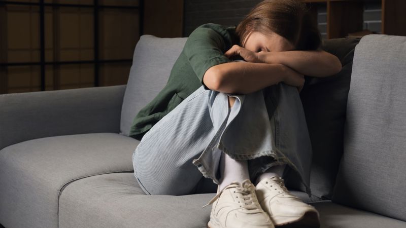 A person upset on a sofa